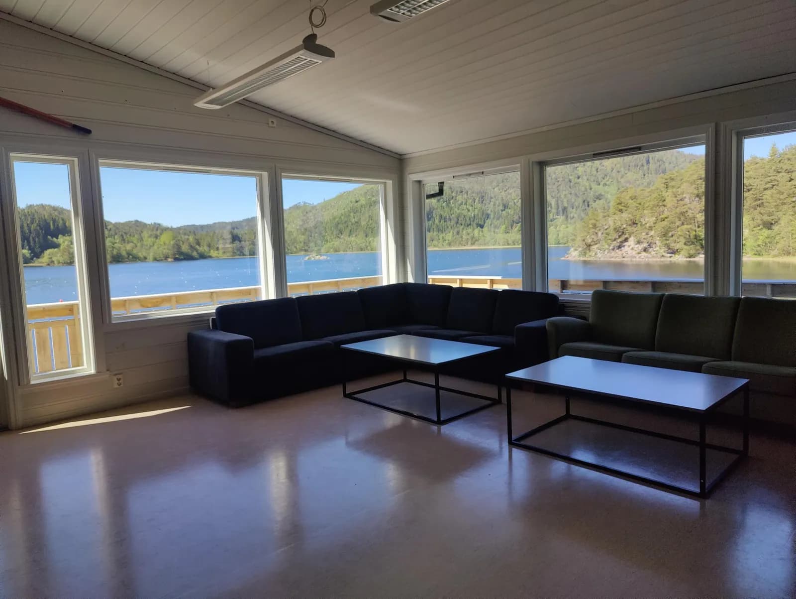 Stuen med sofaer og vinduer mot vannet